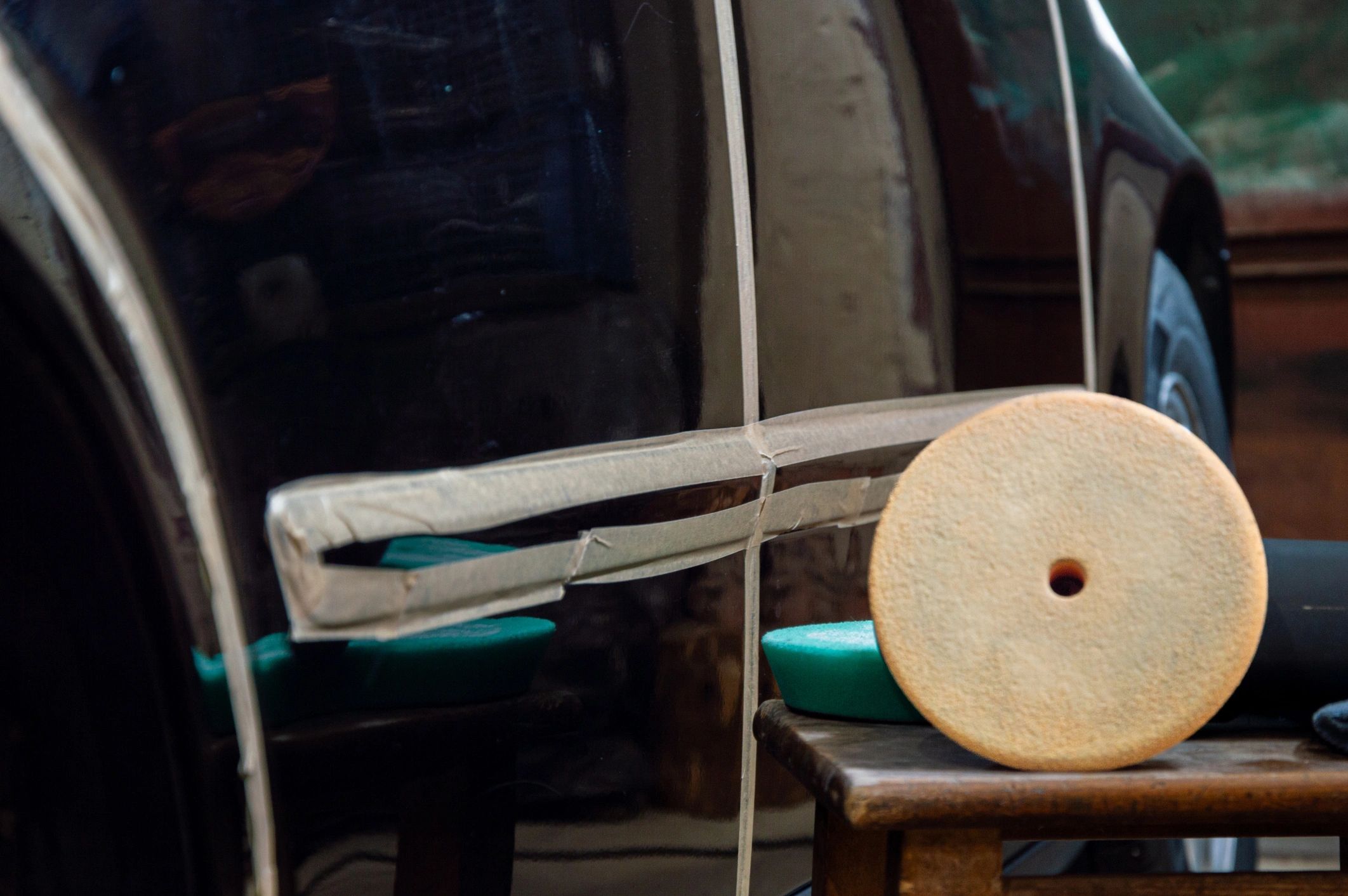 Buffing and polishing tools in use on a vehicle in a detailing workshop
