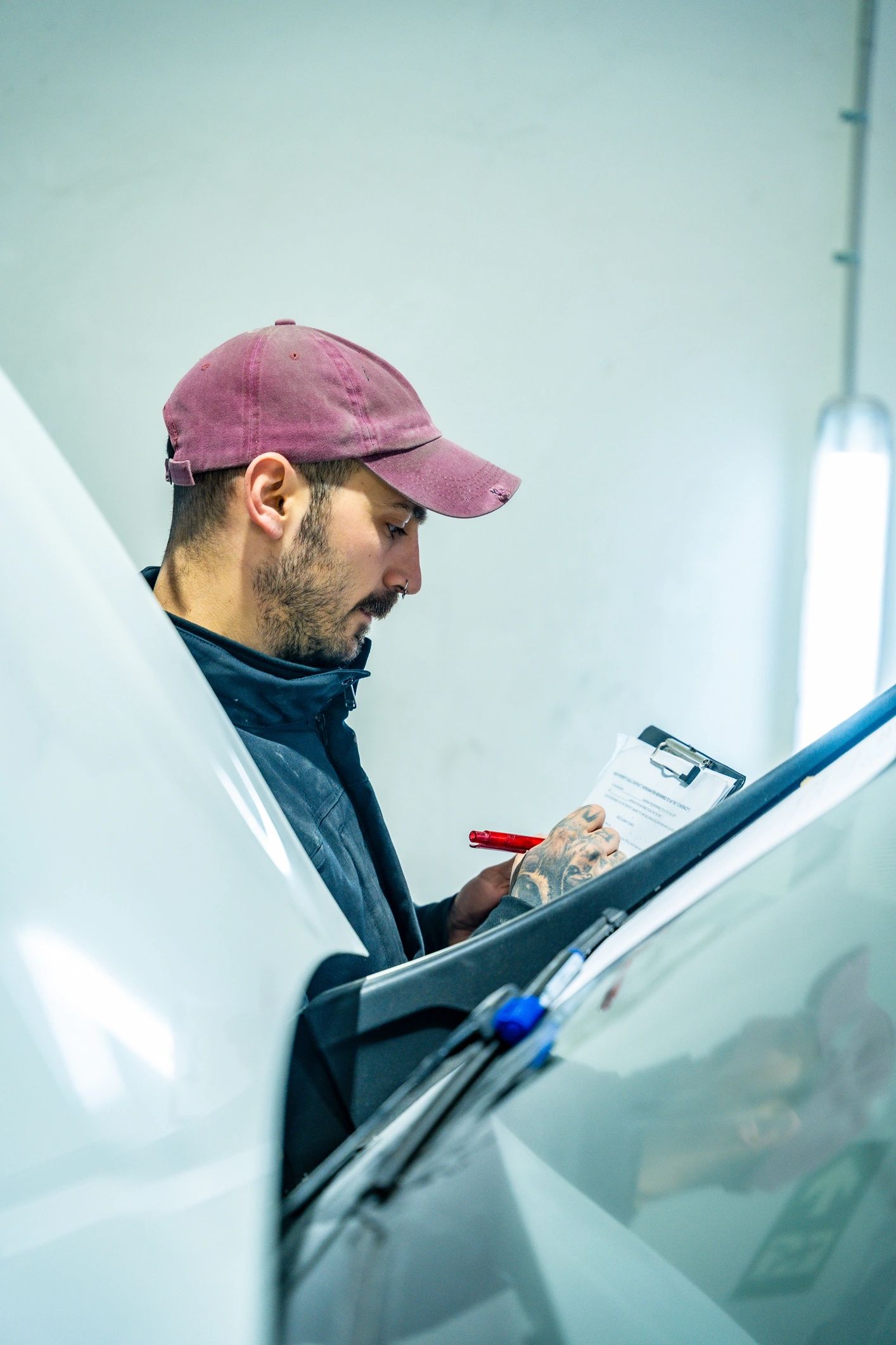 Auto detailing technician inspecting a vehicle in the shop
